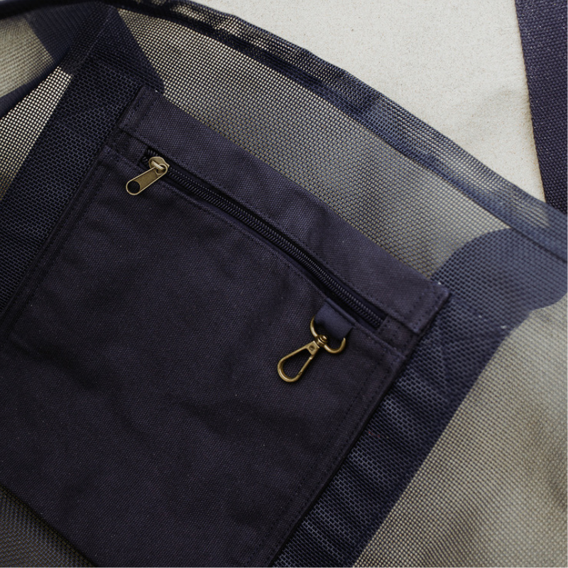 Close-up of the high-quality features of the Sande Kids Beach Hauler - Mini mesh beach bag in Deep Sea Navy. Showcases the internal canvas pocket for valuables and a handy key clip, along with the durable PVC mesh fabric and thick cotton straps.