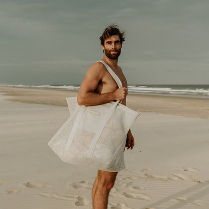 Video of a dad carrying the oversized Sande Kids Beach Hauler mesh beach bag, showcasing its spacious design and durability for family beach outings.