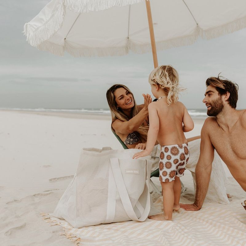 Family enjoying a day at the beach with their Sande Kids Beach Hauler in Sand, highlighting the bag&