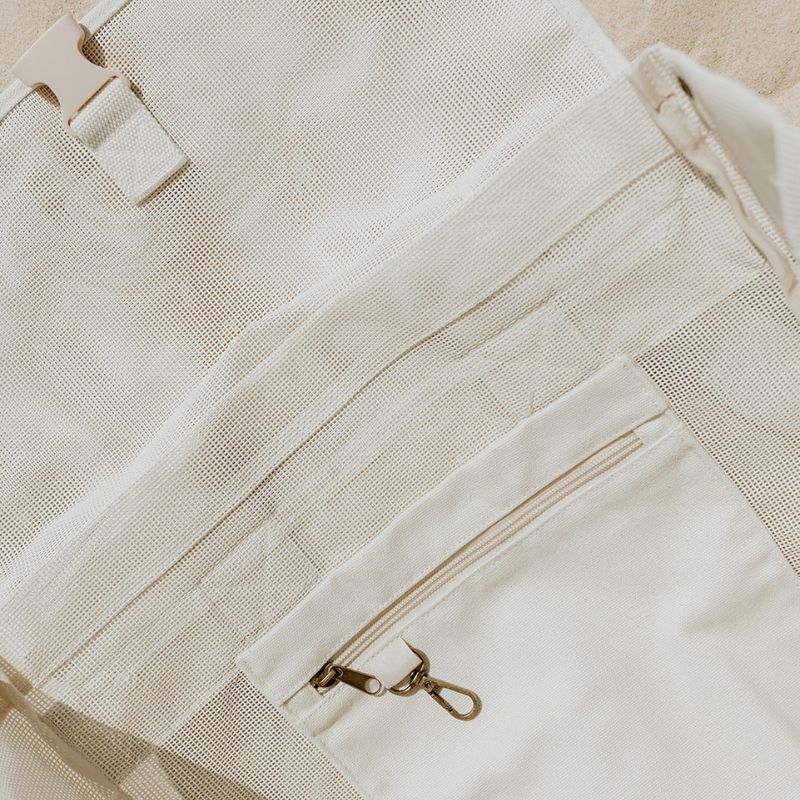 Detailed close-up of the high-quality internal mesh, clip closure, secure canvas pocket, and key clip inside the Sande Kids Beach Hauler backpack in neutral Sand colour.