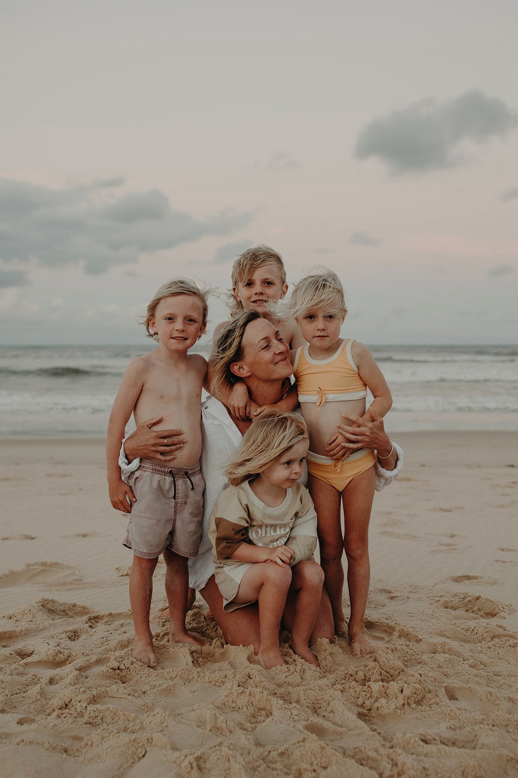 Sande Kids founder Kim huddled with her four children at the beach.