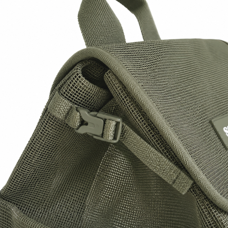 Close up view of the Sande Beach Hauler mesh backpack in Pandanus green, showing the small side clip used to compress the bag.
