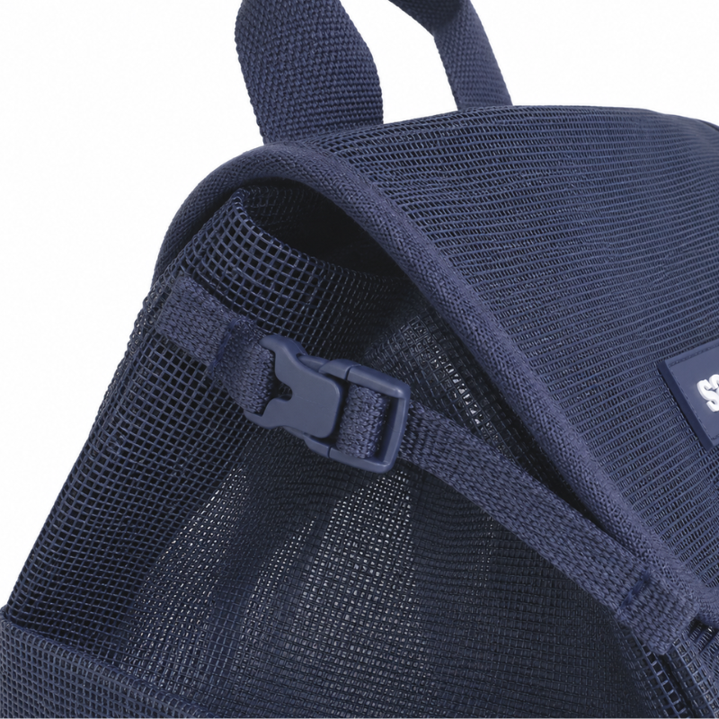 Close up view of the Sande Beach Hauler mesh backpack in Deep Sea navy, showing the small side clip used to compress the bag.