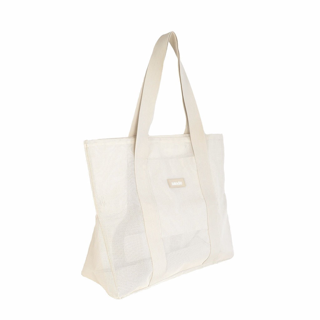 Side view of the Sande Kids Beach Hauler Mini mesh beach bag in Sand/neutral colorway on a white background. This durable and stylish beach bag features a spacious design and breathable mesh fabric, making it ideal for family beach trips and outdoor adventures.